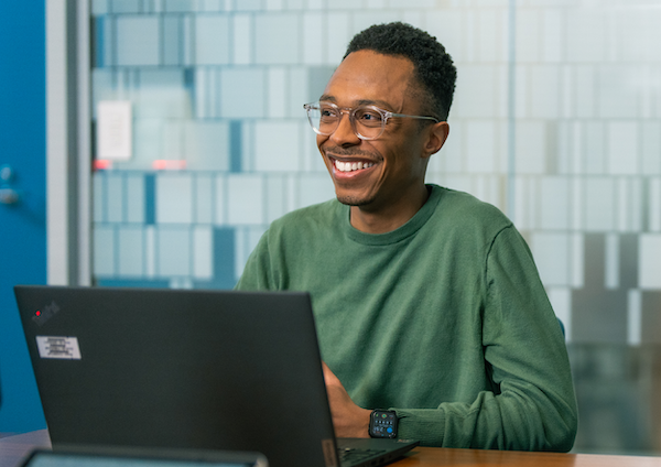 Employee smiling working on his laptop