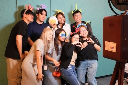 Hong Kong employees posing with props in a photo booth