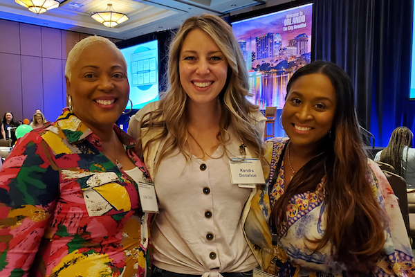 Three employees smiling for a group photo