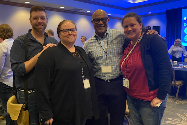 Four employees smiling for a photo