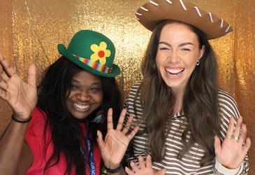 UK employees posing with props in a photo booth