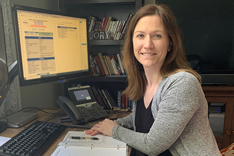 Physician working from home office smiling at camera