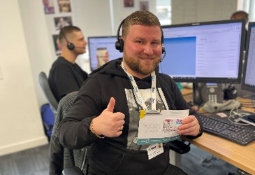 UK employee posing with a recognition certificate
