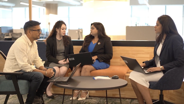 Employees sitting around a table talking