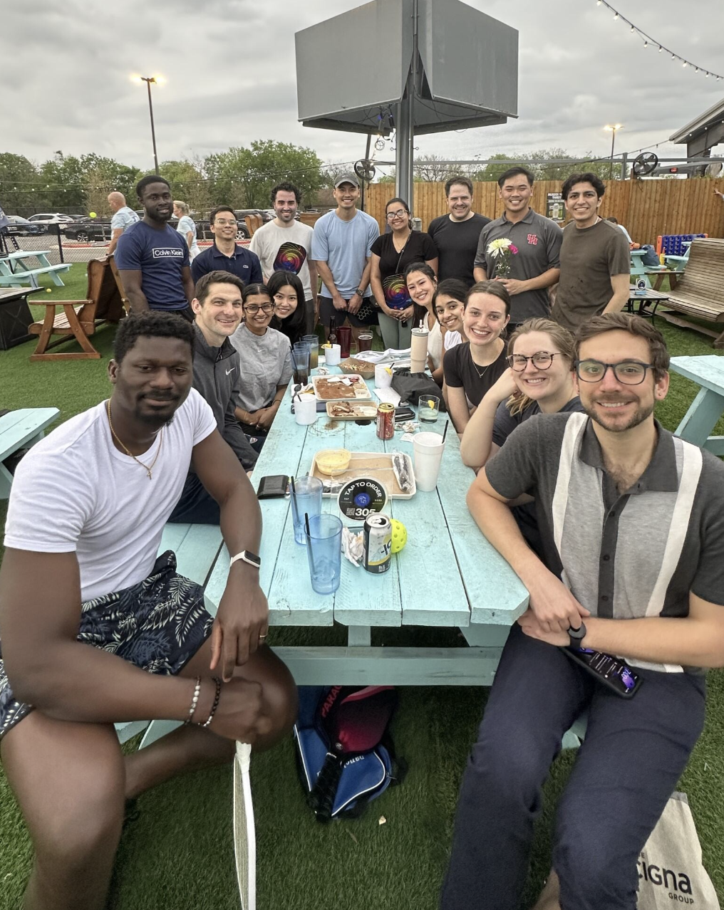 AEDP associates posing for a group photo outside at a picnic table