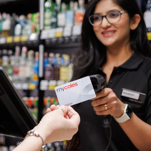 A female Liquorland team member holding a Mycoles discount card at a register