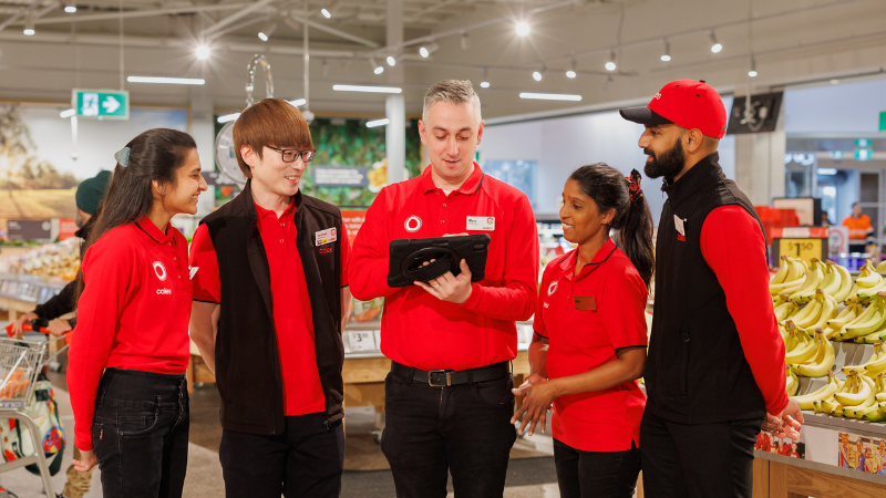 Coles supermarket store team members having a team meeting in the fresh produce section