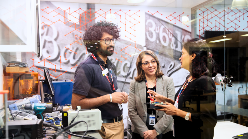 Coles Group Technology team members working together behind glass