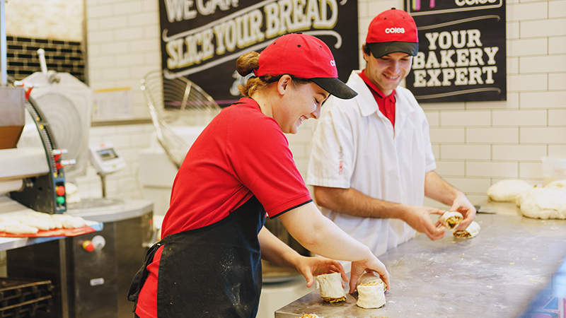 Two bakers working together within the Coles Bakery,