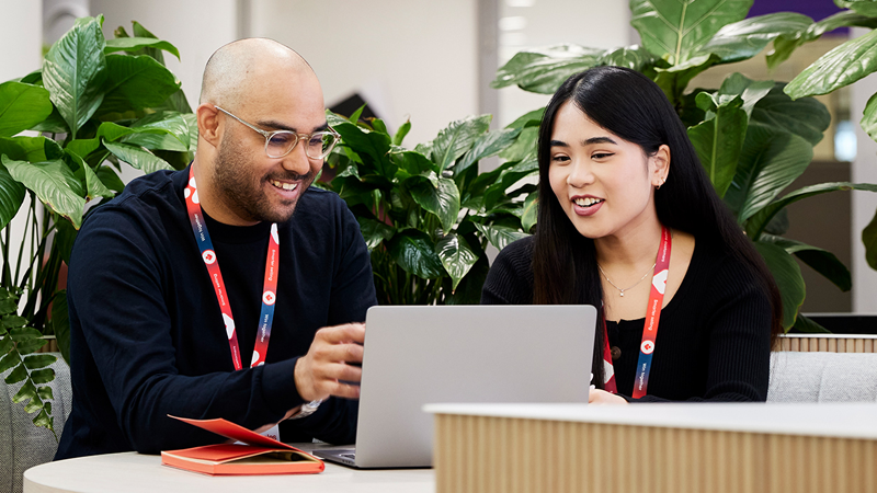 Two Coles corporate team members looking at a laptop