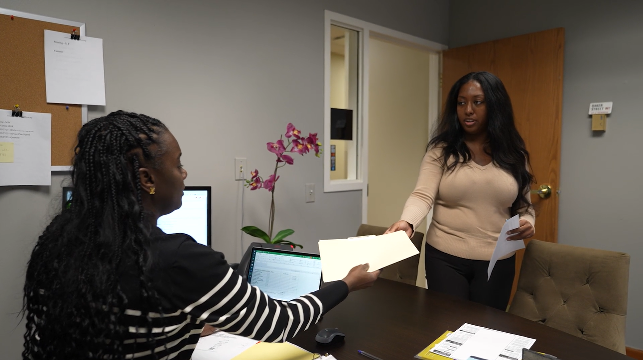 an image of two employees serving residents

