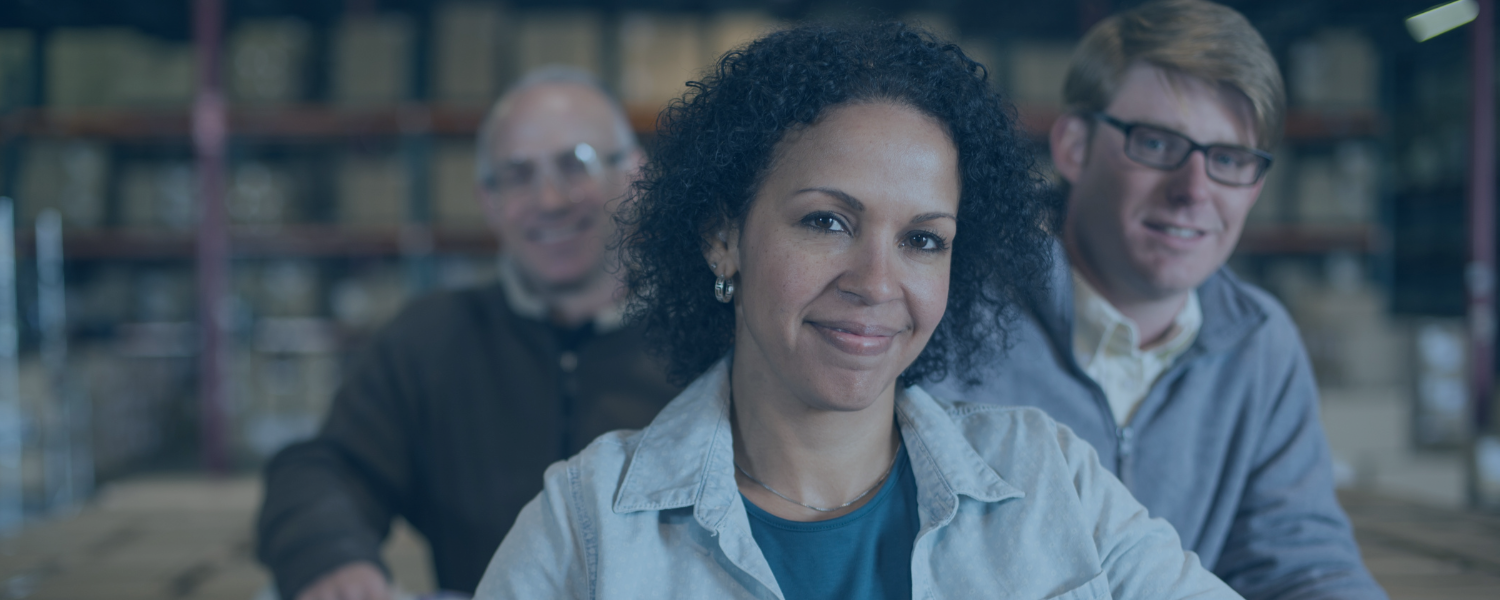 Employees standing in warehouse smiling