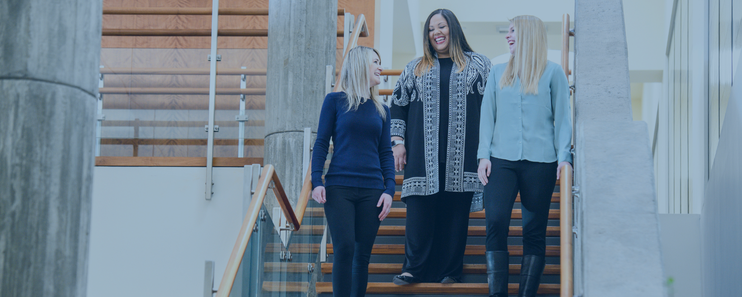 CONMED employees chatting on stairs of Utica building