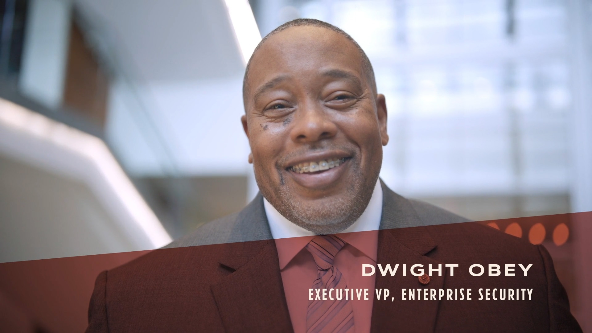 Initial video image of Dwight Obey, Executive VP, Enterprise Security in a suit smliing