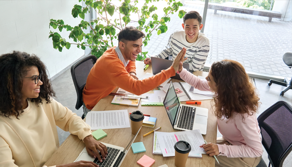 Two coworkers high-five to celebrate a work accomplishment.