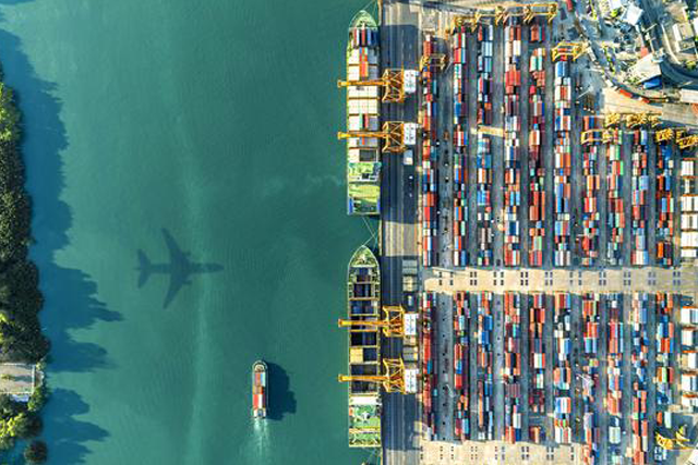 planeaboveseaandharborwithcontainers