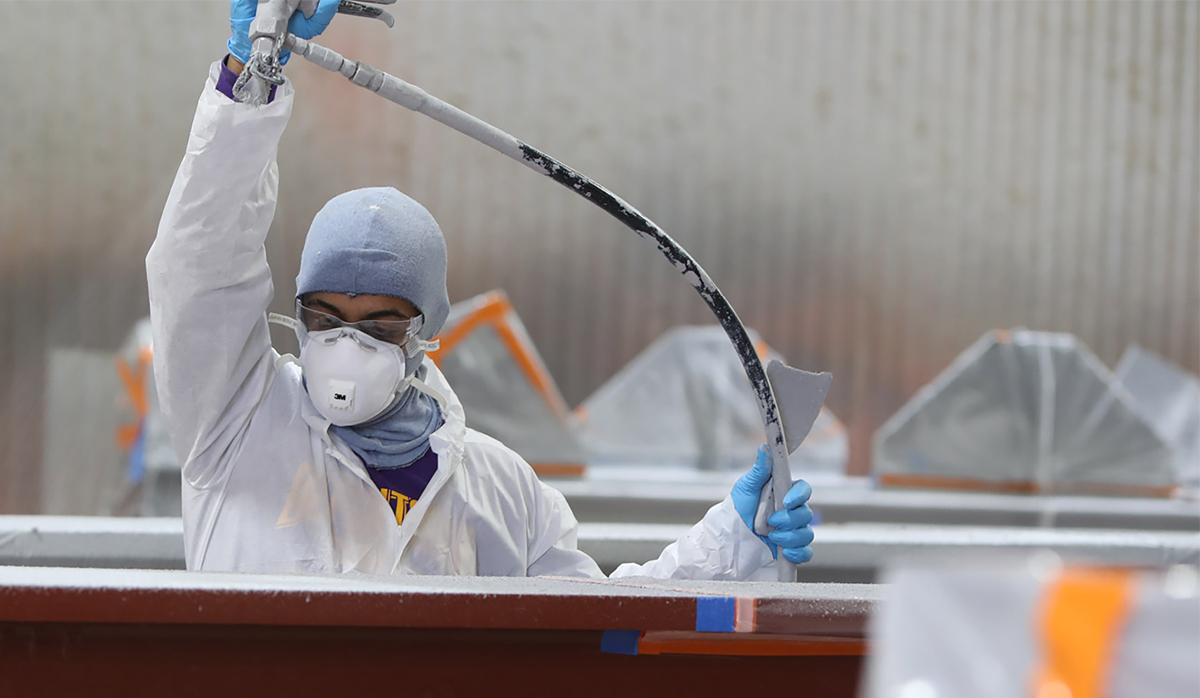 Picture of a Southland Steel worker spraying a steel beam