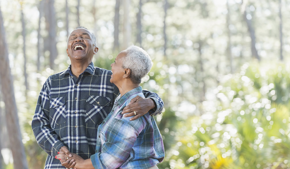 picture of a couple laughing with trees in the background