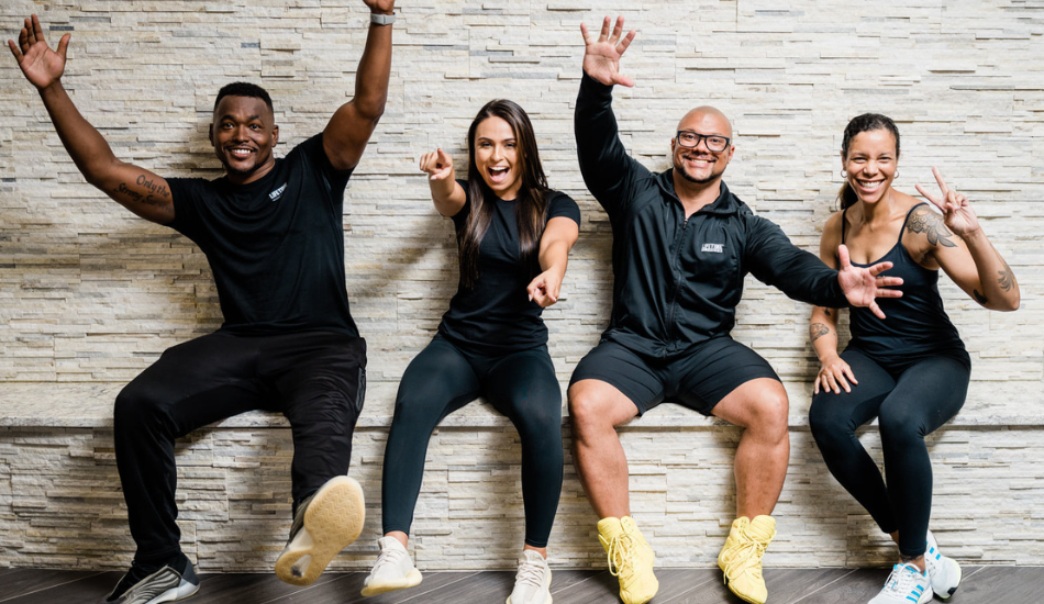 Life Time team members smiling and laughing together at the Life Time club. 