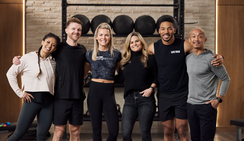 Life Time team members smiling and laughing together at the Life Time club. 