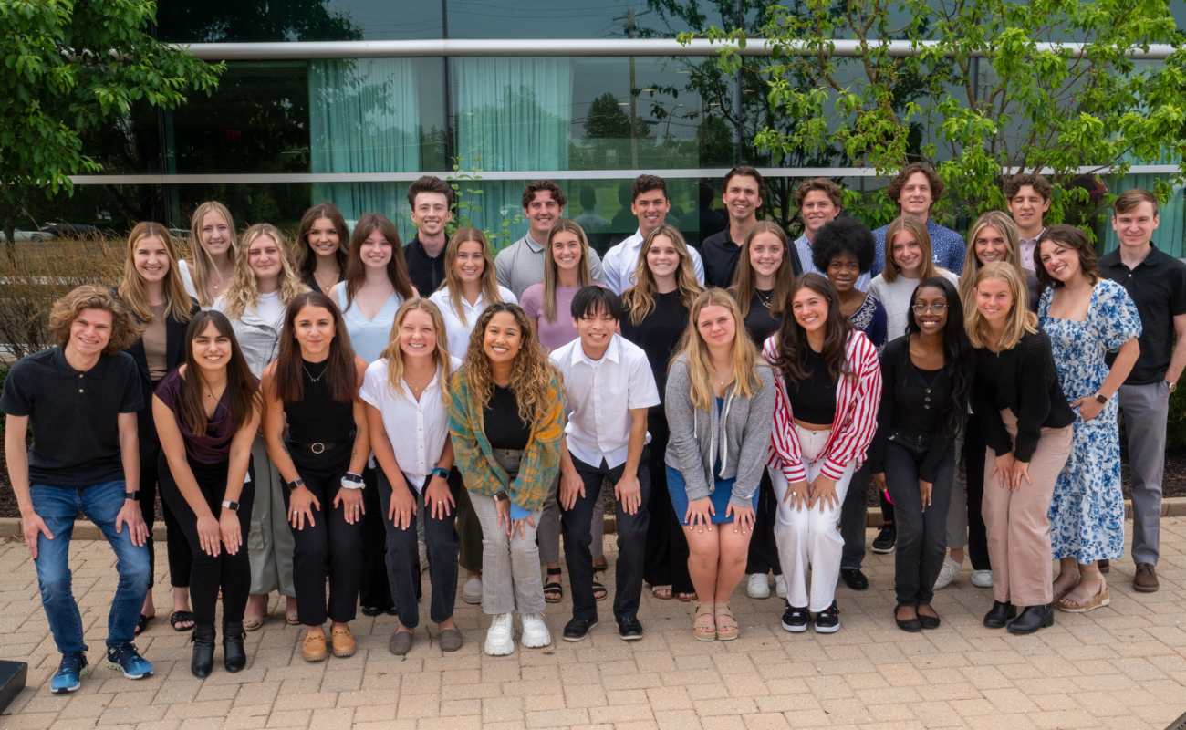 Life Time interns taking a group photo outside of the corporate office.