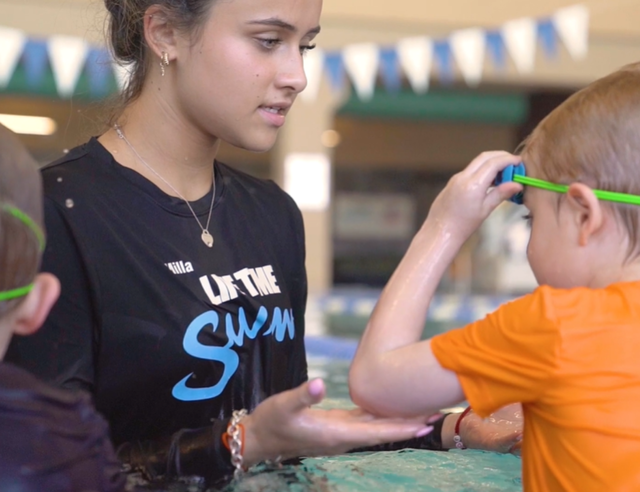 Part Time Female swim instuctor teaching swim lessons at Life Time's pool.