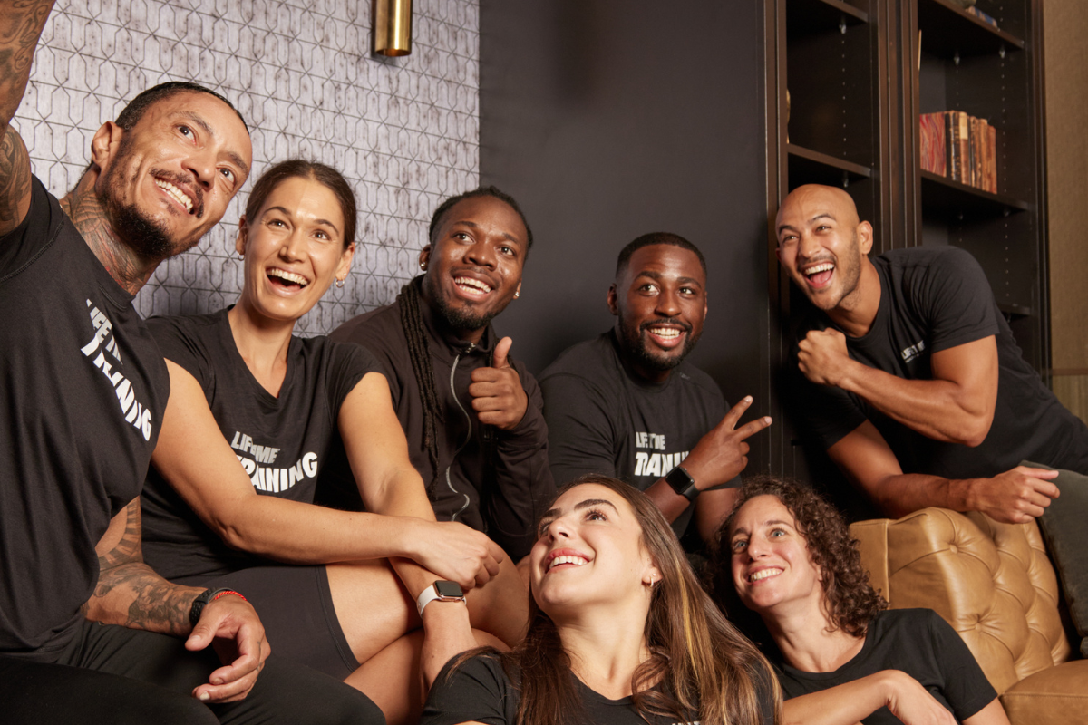 Seven Life Time team members smiling and taking a selfie together.