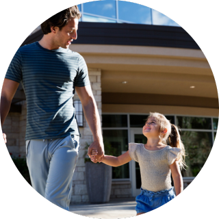 Dad and his daughter holding hands outside of Life Time.