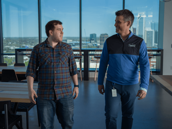 Two male associates walking through the Tech Hub