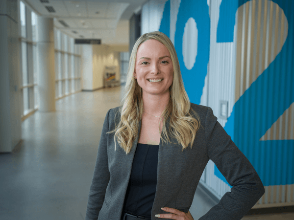 Female associate standing in a hallway of Corporate Headquarters