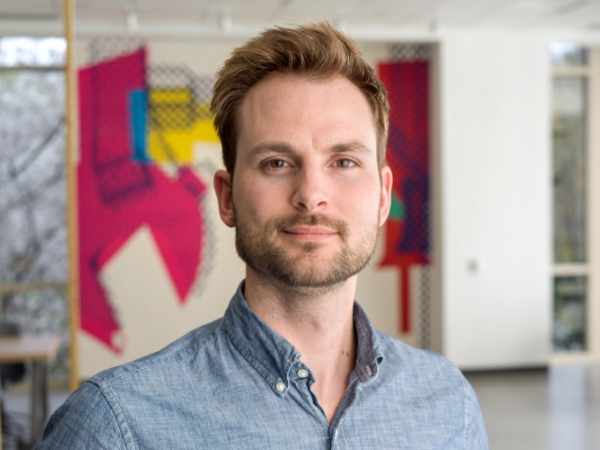 Male associate standing in an open workspace at Corporate Headquarters