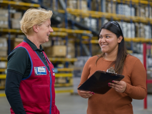 Supply Chain team members discussing work in a distribution center