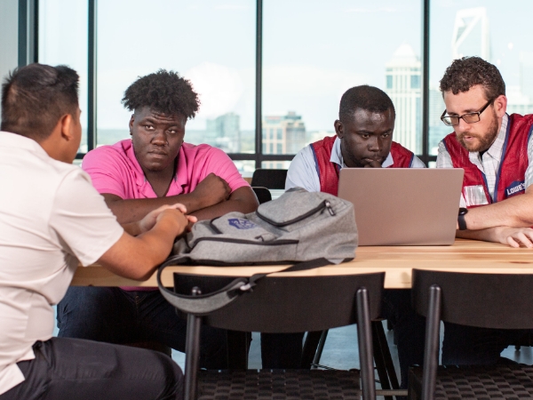 Group of male associates discussing work