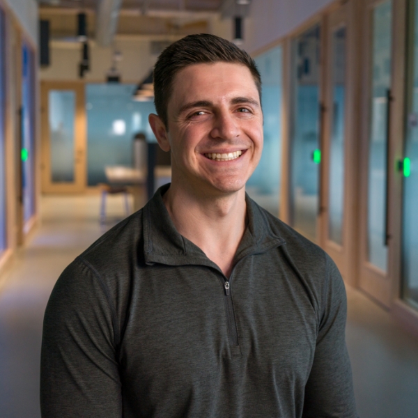 Male associate standing in an open workspace at the Tech Hub