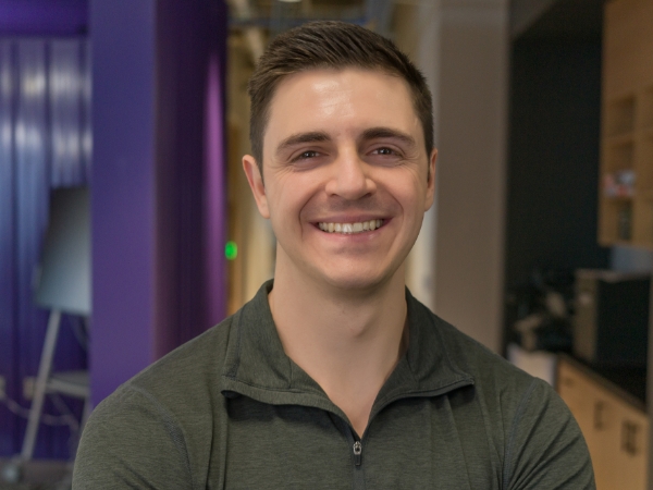 Male associate standing in an open workspace at the Tech Hub