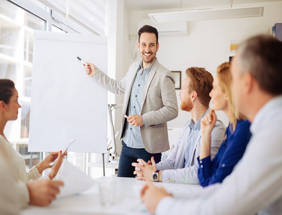 A man presenting to a group of colleagues 