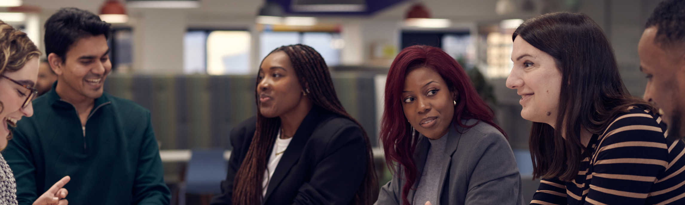 A group of Associates sitting side by side engaging in a coversation