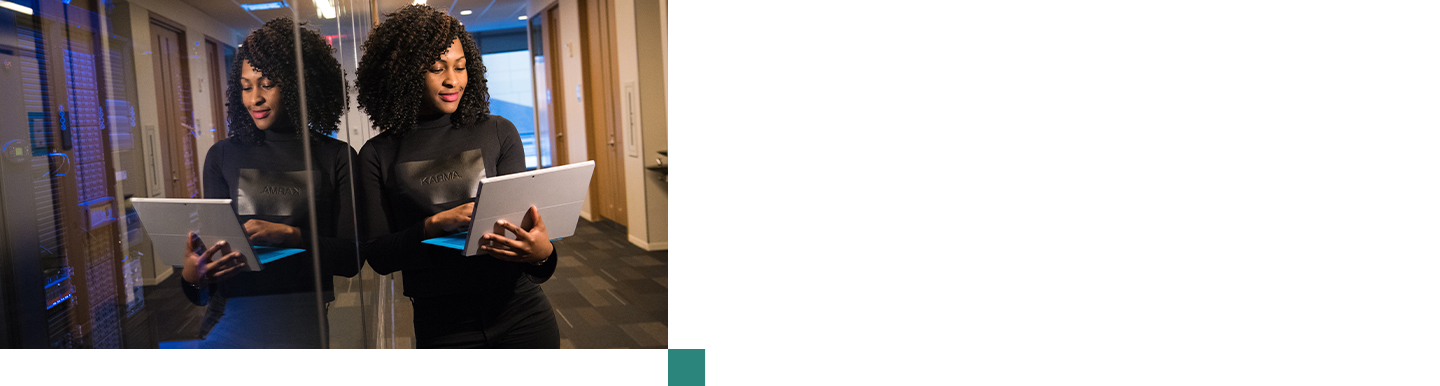 Professional woman in an office holding a laptop