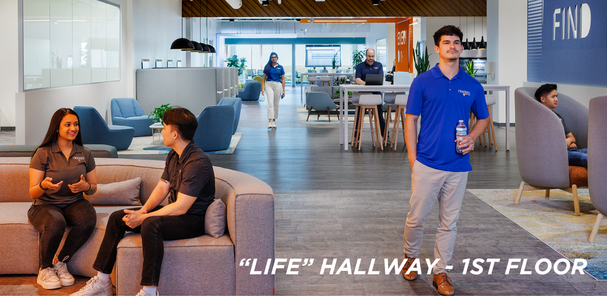 People working at a table in the LIFE hallway 