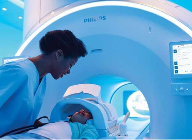 A lady checks on a child at a hospital, using a Philips machine