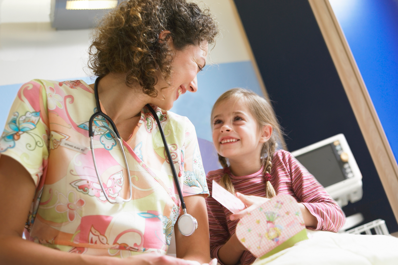 Une infirmière discute avec un enfant dans une salle d’hôpital