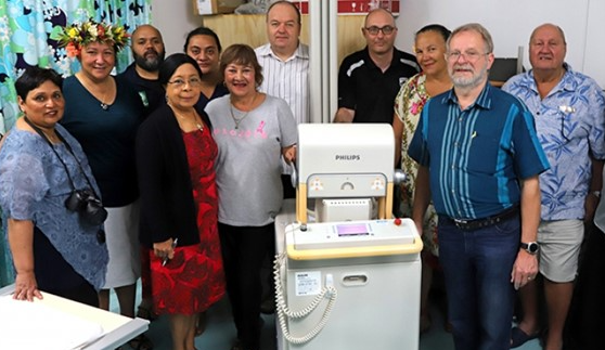 11 people in a hospital room standing around Philips machinery. 