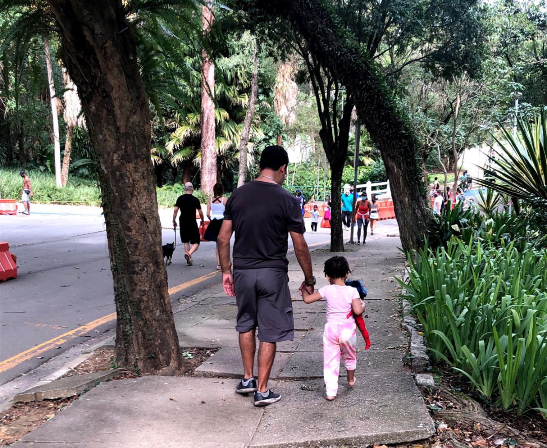 Un padre que lleva de la mano a su hija en el parque