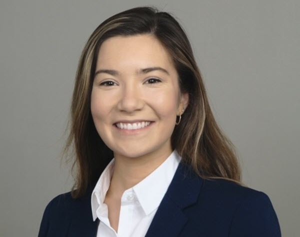 Portrait of Meghan G. showing her smiling at the camera with long, straight brown hair with blonde highlights.