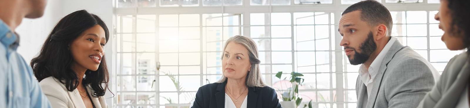 a group of people having a discussion around the conference table