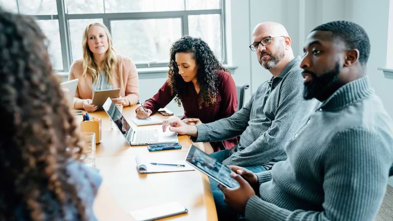 group of colleagues having a discussion around a conference table