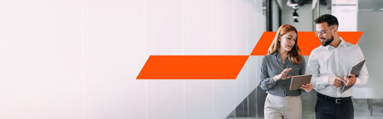 two people having a discussion while walking down the corridor