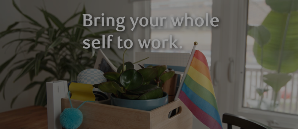 Box of work items and pride flag with text reading 'Bring your whole self to work.'