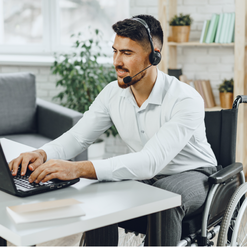 Man in wheelchair working on laptop.