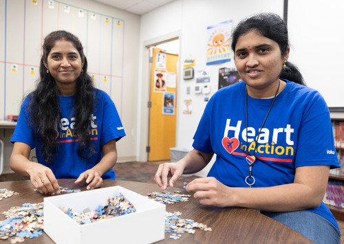 Two Southwest Employees putting a puzzle together at a commumity volunteer event. 